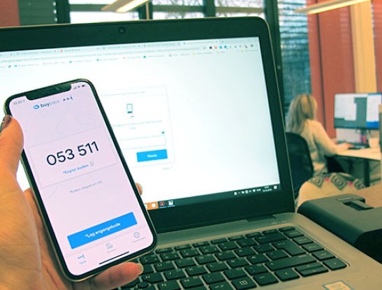 Hand holding mobile phone with Buypass Code app in use Hand holding mobile phone with Buypass Code app in use