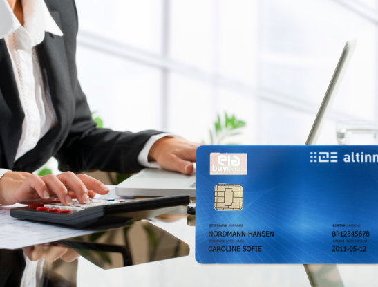 Woman's hands working with a calculator and laptop. Buypass smart card with Altinn design Woman's hands working with a calculator and laptop. Buypass smart card with Altinn design